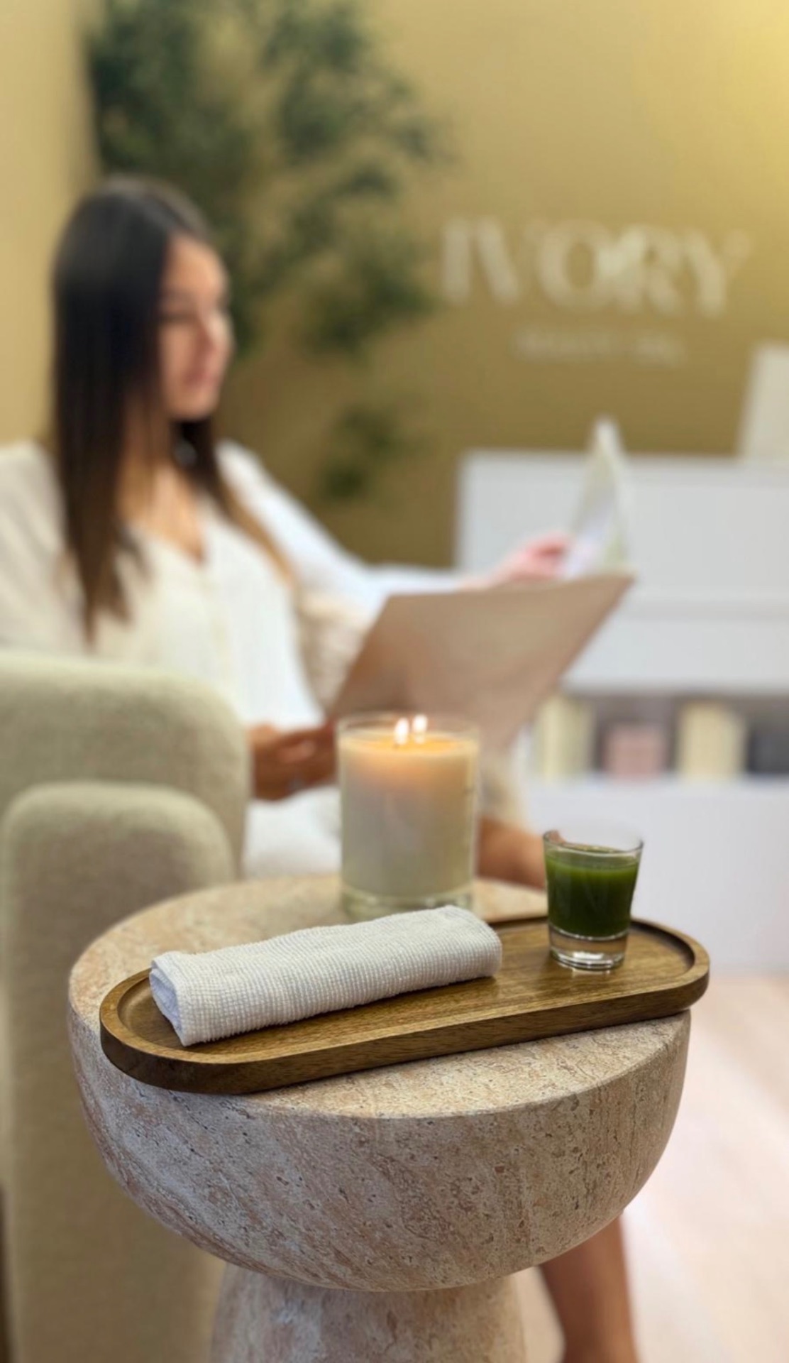 Guest relaxing in the Ivory Beauty Spa lobby with candle and celery juice